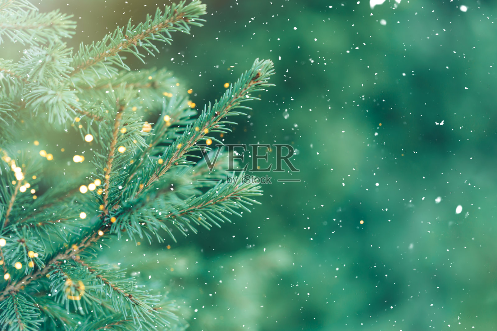 绿色的树枝圣诞树在花环的背景下飘落的雪照片摄影图片