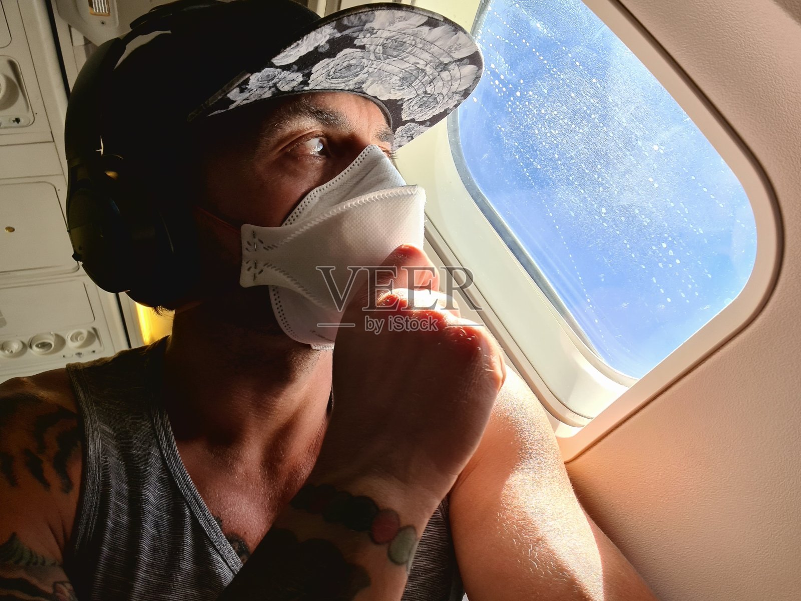 一名男子在国际航班上戴着口罩照片摄影图片