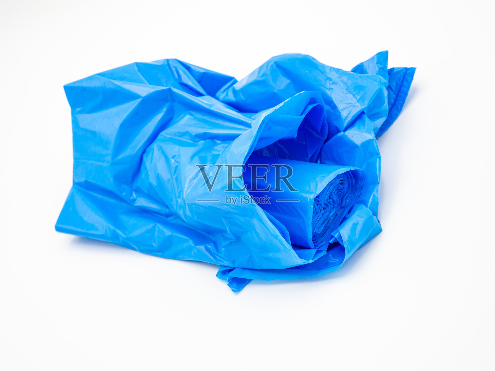 蓝色塑料垃圾袋卷起来，白色背景照片摄影图片