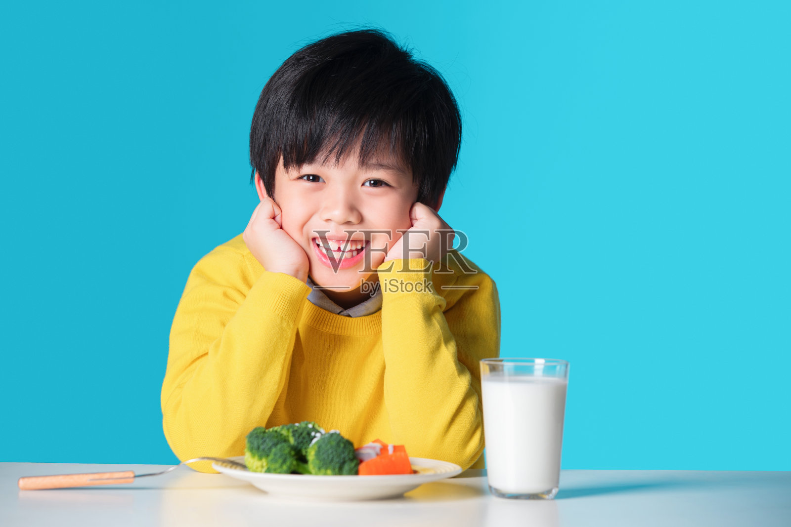 快乐的小男孩吃蔬菜照片摄影图片