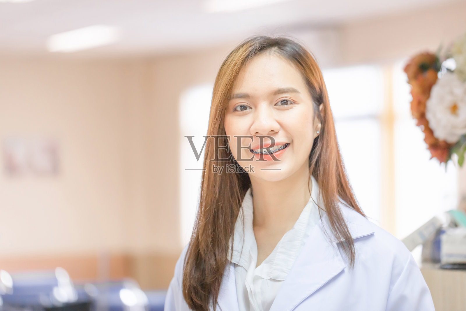 开朗的年轻女医生在医院摆姿势微笑的肖像，医疗保健和医生服务照片摄影图片