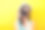 一个摄影师的近距离拍摄在一个数码相机在假期。她穿着夏季休闲装，戴着一顶亮黄色的帽子素材图片