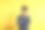 画室里一个以黄色为背景的年轻人的肖像。素材图片